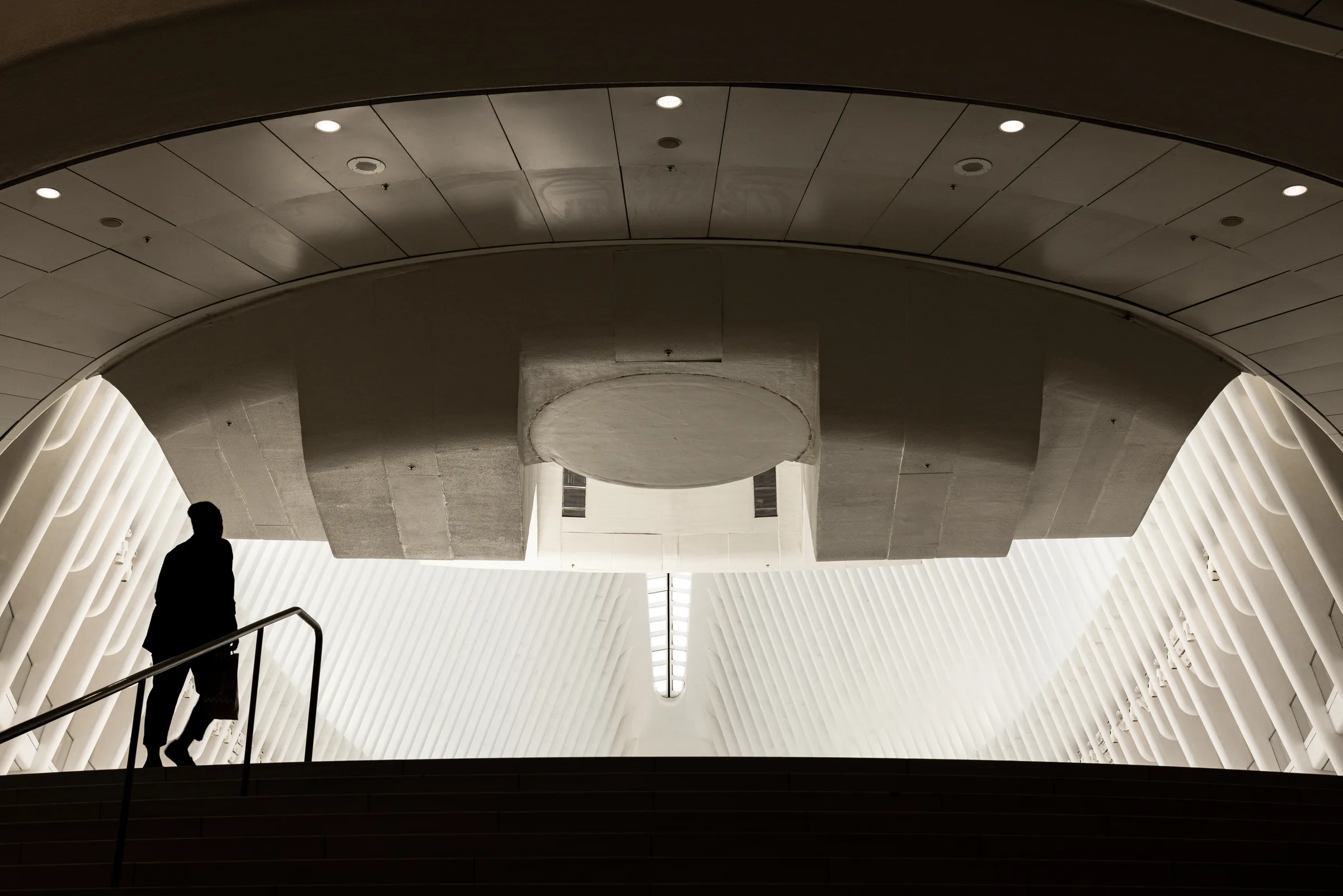 Silhouette of a person descending a staircase inside the Oculus transit hub, New York, by ARCHTRAITS