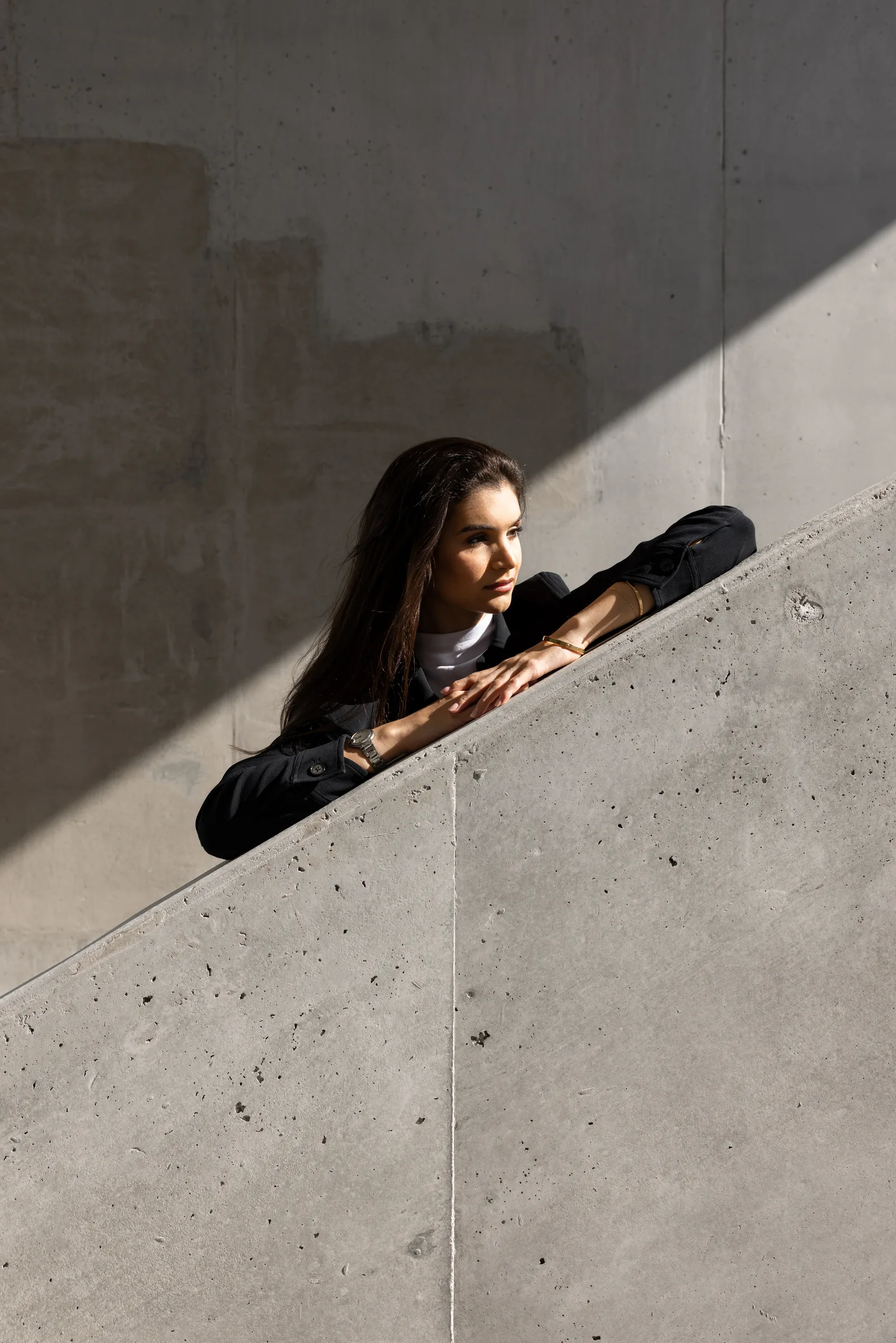 Symmetric view looking up at converging concrete beams meeting at a corner where a woman stands, Miami Dade College, Florida, by ARCHTRAITS