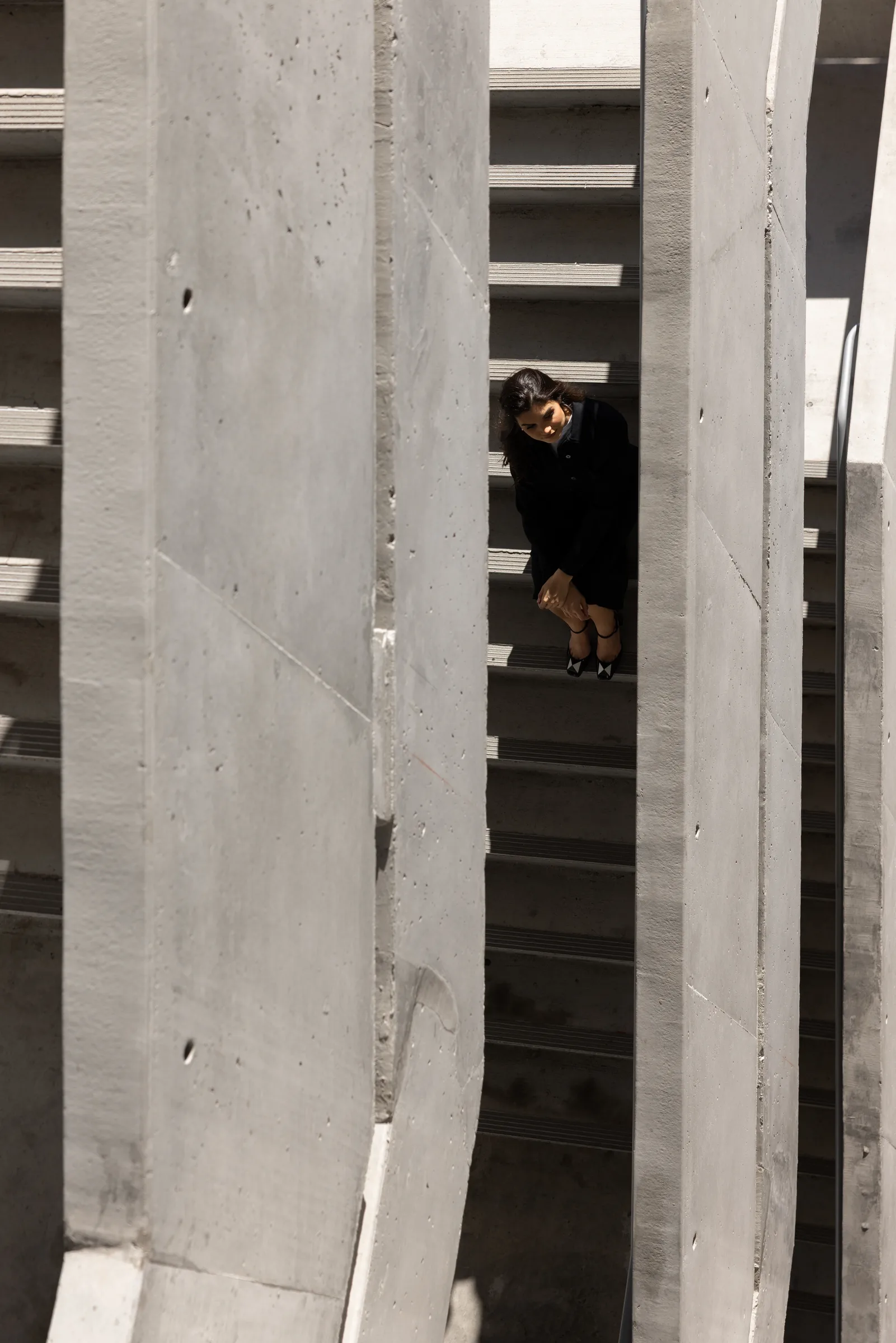 Close portrait of a woman seated on a staircase in soft directional light at Miami Dade College, Florida, by ARCHTRAITS
