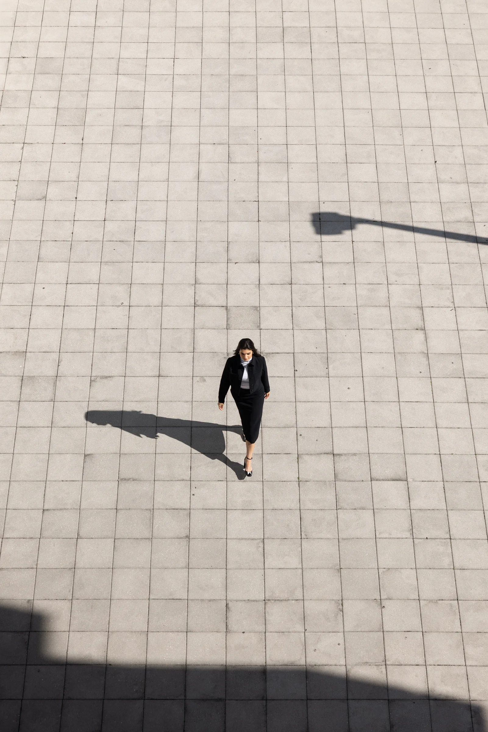 Aerial view down a narrow gap between concrete fins at a woman descending the stairs below, Miami Dade College, Florida, by ARCHTRAITS